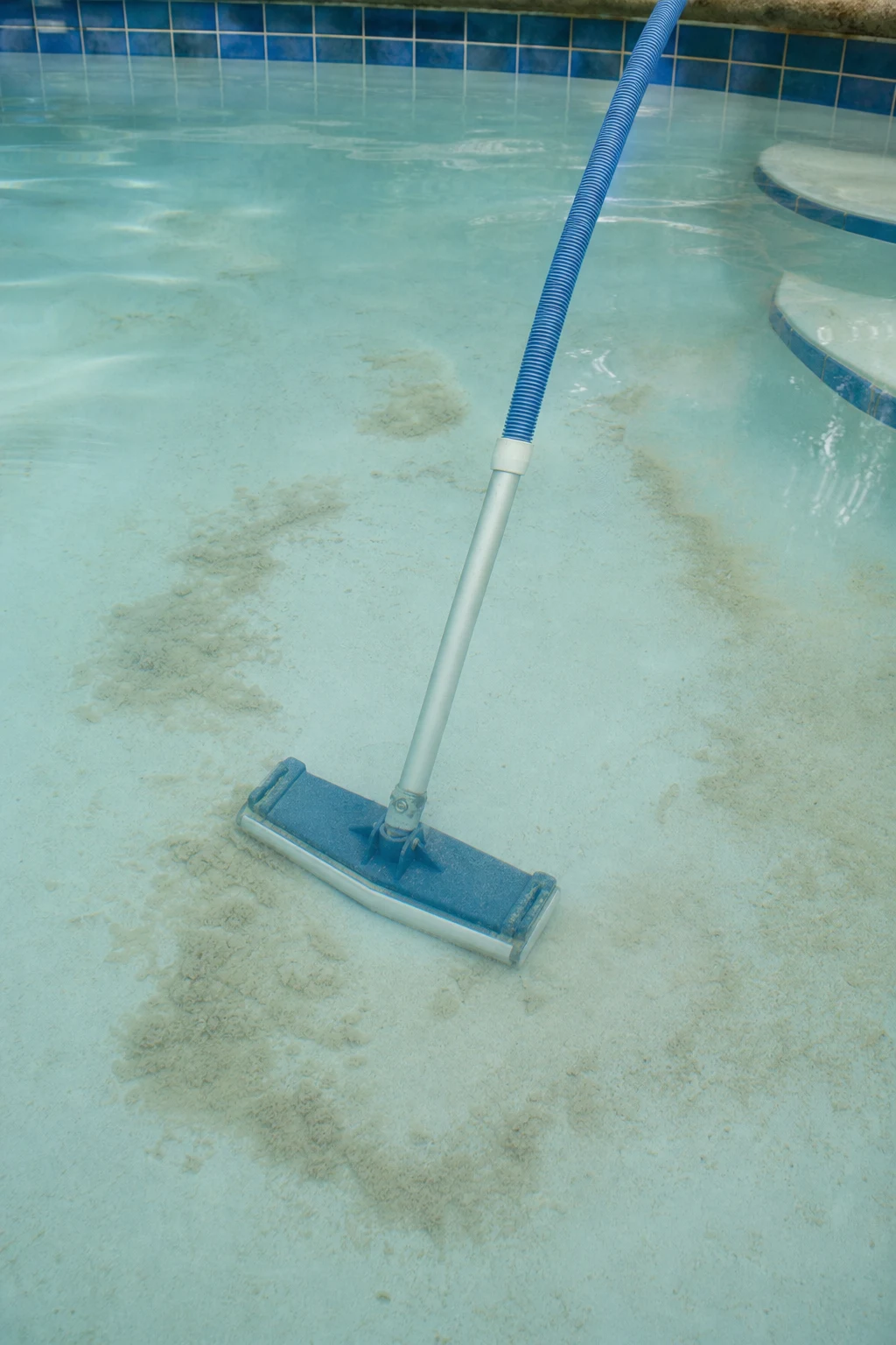 Vacuuming settled pool floc sediment to waste from the pool floor